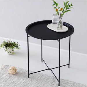 Spot on Round metal black table with cups and plant on top